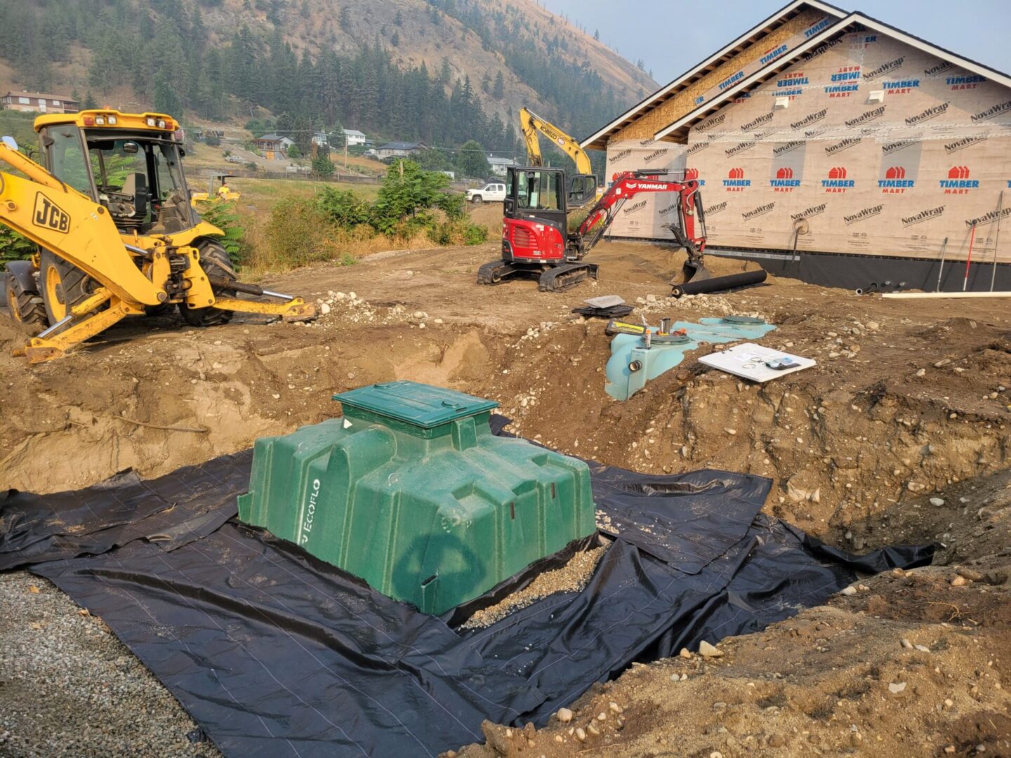 A green tank sitting in the middle of a dirt field.
