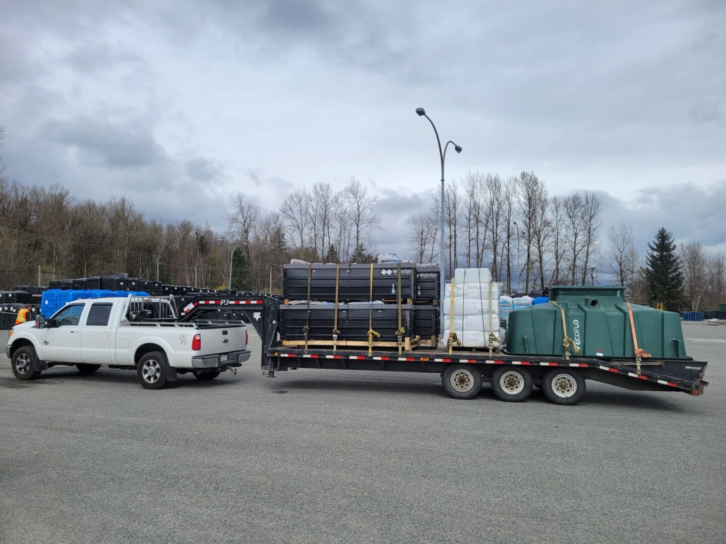 A truck with a trailer full of pipes and tanks.