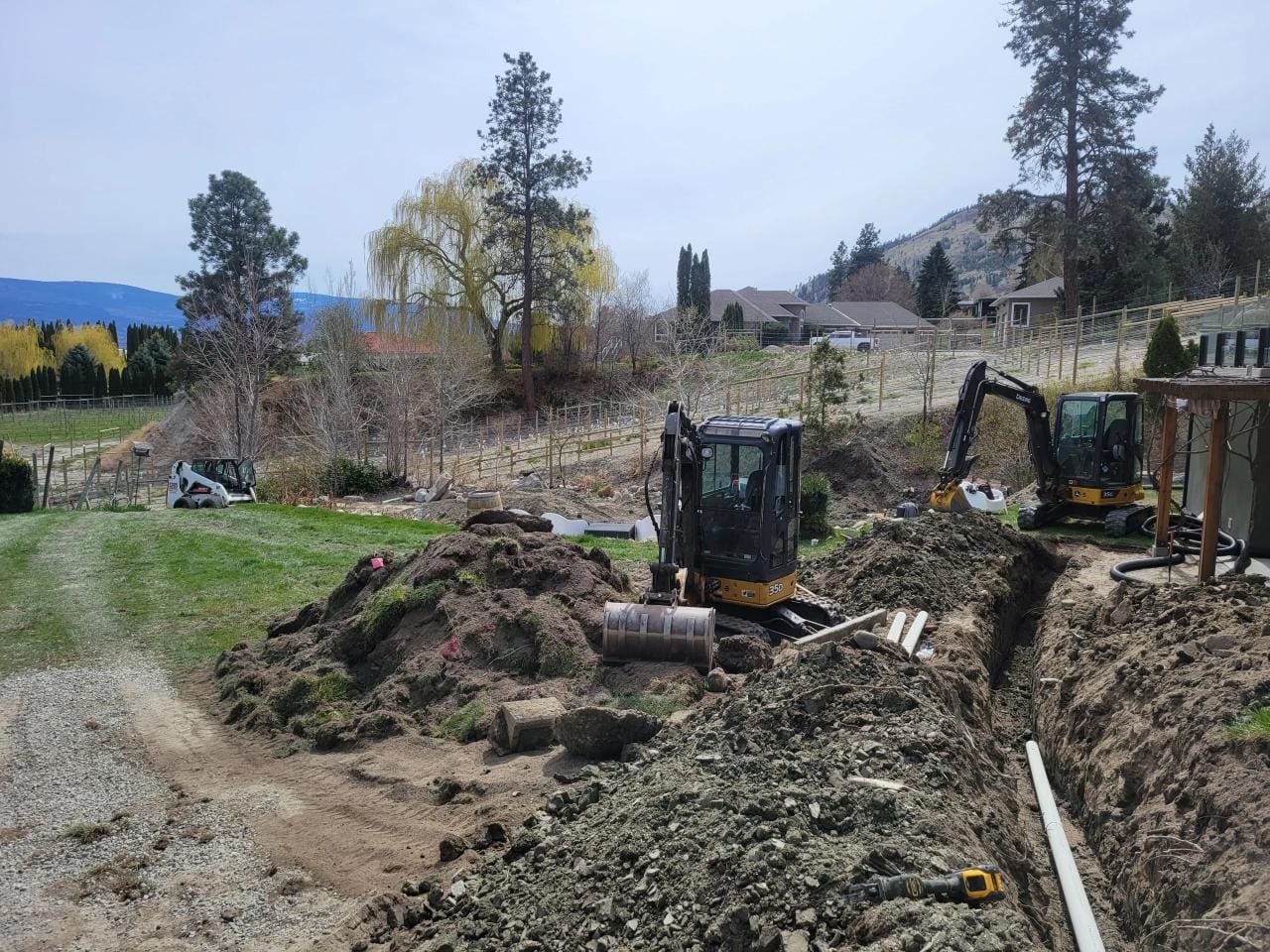 A couple of large construction equipment on top of dirt.