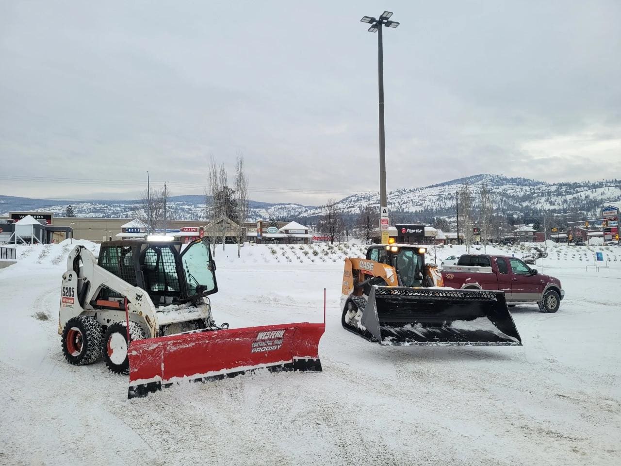 A person on a tractor with a plow in the snow.