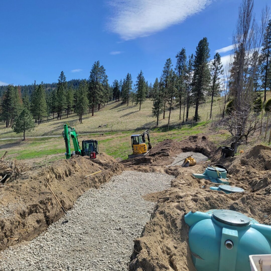 A dirt road with water tanks and construction equipment.