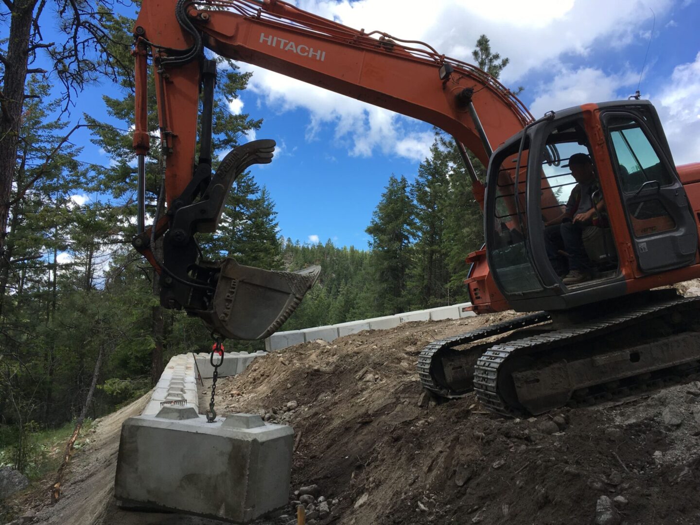 A large orange and black construction vehicle on the side of a road.
